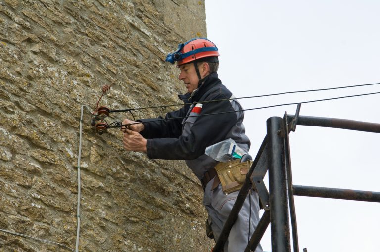 Male electrician on platform fixing house electricity supply